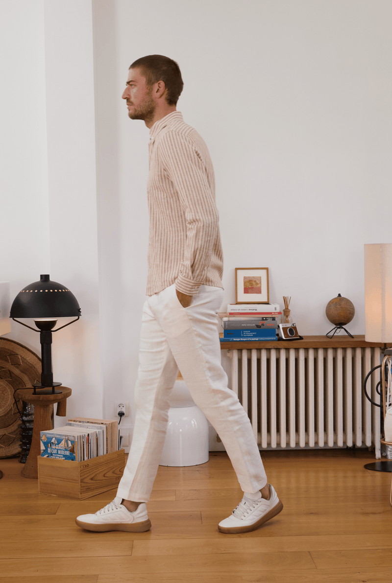 Pantalon en lin blanc homme chemise rayée de profil 